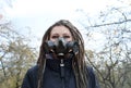 Portrait of a Woman in a black jacket with dreadlocks and a gas mask with spikes. Woman posing in autumn park Royalty Free Stock Photo