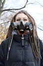 Portrait of a Woman in a black jacket with dreadlocks and a gas mask with spikes. Woman posing in autumn park Royalty Free Stock Photo