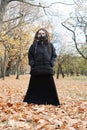 Portrait of a Woman in a black jacket and a long skirt with dreadlocks and a gas mask with spikes. Woman posing in Royalty Free Stock Photo