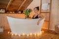 Portrait of woman in black underwear relaxing and spending weekend at home. Taking bath with glass of wine on food tray Royalty Free Stock Photo