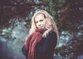 Portrait of a woman with blond curly hair on the background of the winter forest