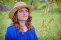 Portrait of a woman in a blue dress and hat on the background of a spring forest, copy space for text Royalty Free Stock Photo