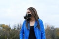 Portrait of a Woman in a blue jacket and dreadlocks in a gas mask with spikes. Royalty Free Stock Photo