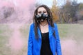 Portrait of a Woman in a blue jacket and dreadlocks in a gas mask with spikes. woman standing in smoke Royalty Free Stock Photo