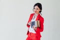 Portrait of a beautiful woman with books in a red business suit in the office Royalty Free Stock Photo