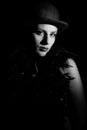 Portrait of woman in bowler hat on black background in black and white Royalty Free Stock Photo