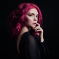 Portrait of a woman with bright colored flying hair, all shades of pink. Hair coloring, beautiful lips and makeup. Hair fluttering