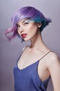 Portrait of a woman with bright colored flying hair, all shades of purple. Hair coloring, beautiful lips and makeup. Hair