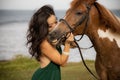 Portrait of woman and brown horse. Asian woman kissing horse. Romantic concept. Human animals relationship. Nature concept. Bali