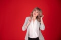 Portrait of a woman business blonde in bright jacket on redbackground .Copy space