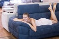woman buyer lying on the sofa in furniture shop Royalty Free Stock Photo