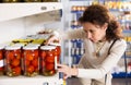 Portrait of woman buying canned tomatoes at grocery store Royalty Free Stock Photo