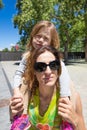 Portrait of woman carrying a child on shoulders on the street