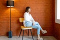Portrait of a woman on chair on brick wall background Royalty Free Stock Photo