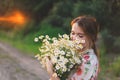 Portrait young beautiful woman with chamomile flowers at sunset. Royalty Free Stock Photo