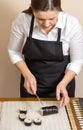 Portrait of woman chef cutting japanese sushi roll Royalty Free Stock Photo