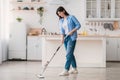 Portrait of woman cleaning floor in kitchen with spray mop Royalty Free Stock Photo