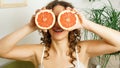 Portrait of woman covering her eye with grapefruit Royalty Free Stock Photo