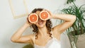 Portrait of woman covering her eye with grapefruit Royalty Free Stock Photo