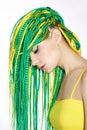 Portrait of a woman with creatively colored hair in green and yellow color. Colorful bright dreadlocks, beautiful modern makeup Royalty Free Stock Photo