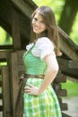 Portrait of woman in dirndl in front of wooden shack Royalty Free Stock Photo