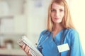 Portrait of woman doctor with stethoscope at hospital corridor, holding a folder. Royalty Free Stock Photo