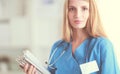 Portrait of woman doctor with stethoscope at hospital corridor, holding a folder. Royalty Free Stock Photo