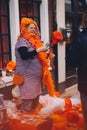 Portrait of woman dressed in orange, crazy hat, selling junk on King`s Day festivity Royalty Free Stock Photo