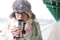 Portrait of woman drinking coffee from insulated drink container during winter