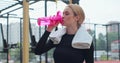 Portrait of a woman drinking water from the pink sport bottle. Fit girl drink water from bottle. Rest after hard workout Royalty Free Stock Photo