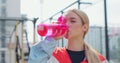 Portrait of a woman drinking water from the pink sport bottle. Fit girl drink water from bottle. Rest after hard workout Royalty Free Stock Photo