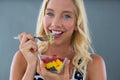 Portrait of woman eating fruit salad in bowl Royalty Free Stock Photo