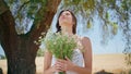 Portrait woman embracing flowers in rural nature. Beautiful smiling lady bouquet Royalty Free Stock Photo