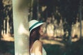 Portrait of a woman enjoying her time in nature wearing a hat and white flowery dress