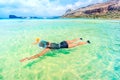 portrait of young woman enjoying sunny day on beach wearing snorkeling mask, diving and swimming in sea