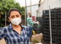 Portrait of woman farmer wearing protective mask in the backyard of house Royalty Free Stock Photo