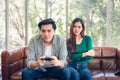 Portrait of Woman Feeling Offended With Her Boyfriend When He Playing Video Games While Sitting on The Couch in Living Room. Royalty Free Stock Photo