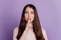 Portrait of woman finger close lips on purple background