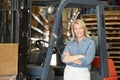 Portrait Of Woman With Fork Lift Truck In Warehouse Royalty Free Stock Photo