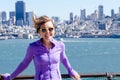 Portrait of a woman in front of the San Francisco skyline, as seen from the water in the bay. Wind blown hair Royalty Free Stock Photo