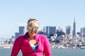 Portrait of a woman in front of the San Francisco skyline, as seen from the water in the bay. Wind blown hair Royalty Free Stock Photo