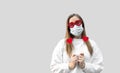 Portrait of woman in funny glasses and medical protective wearing mask holding in hands red hearts. concept of valentines day Royalty Free Stock Photo