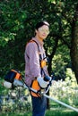 Portrait of woman gardener mowing the grass on backyard using string trimmer Royalty Free Stock Photo