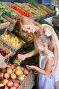 Portrait of woman and girl buying fresh fruits Royalty Free Stock Photo