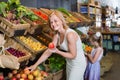 Portrait of woman and girl buying fresh fruits Royalty Free Stock Photo