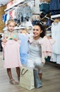 Portrait of woman and girl shopping kids apparel in clothes store Royalty Free Stock Photo