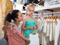 Portrait of woman and girl shopping white baby apparel in cloth