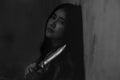 Portrait woman hand holding knife weapon, staring ahead at stress,in dark and dirty room,concept of loneliness, sadness from bully