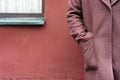 Portrait of a woman hand in the pocket in a burgundy coat view from the back