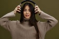 portrait woman in headphones listening to music emotions Green background